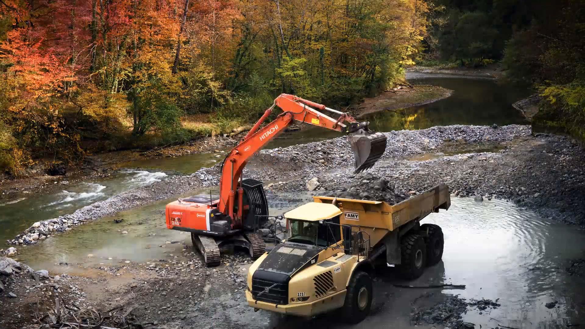 Travaux de restauration De La Continuité Écologique Du Chéran, pelleteuse et camion au milieu d'un paysage de rivière avec pierres nature Arbres Rivière